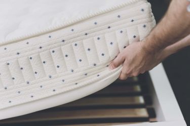 close-up-man-lifted-mattress-look-bed-frame.jpg